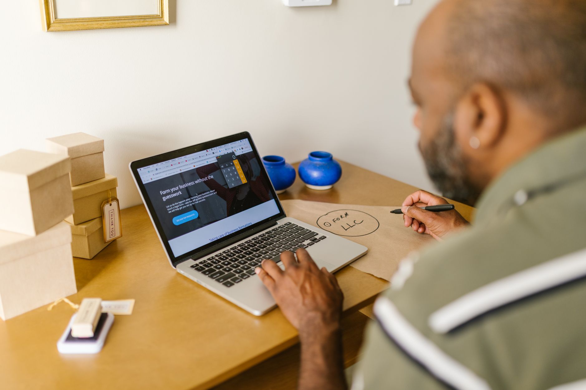 Entrepreneur à son bureau, travaillant sur un ordinateur portable pour planifier son activité de repurposing de contenu.